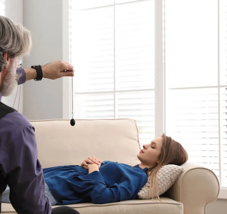 Séance d'hypnose d'une femme allongée sur une canapé beige