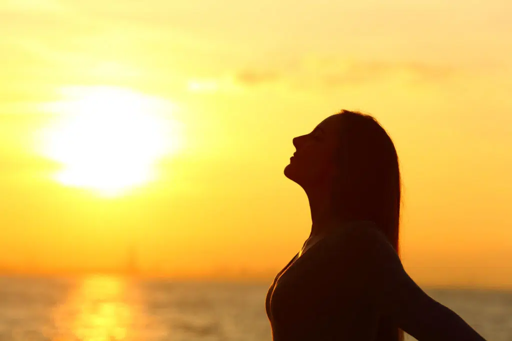 Silhouette d'une femme avec don de voyance à la plage au coucher du soleil