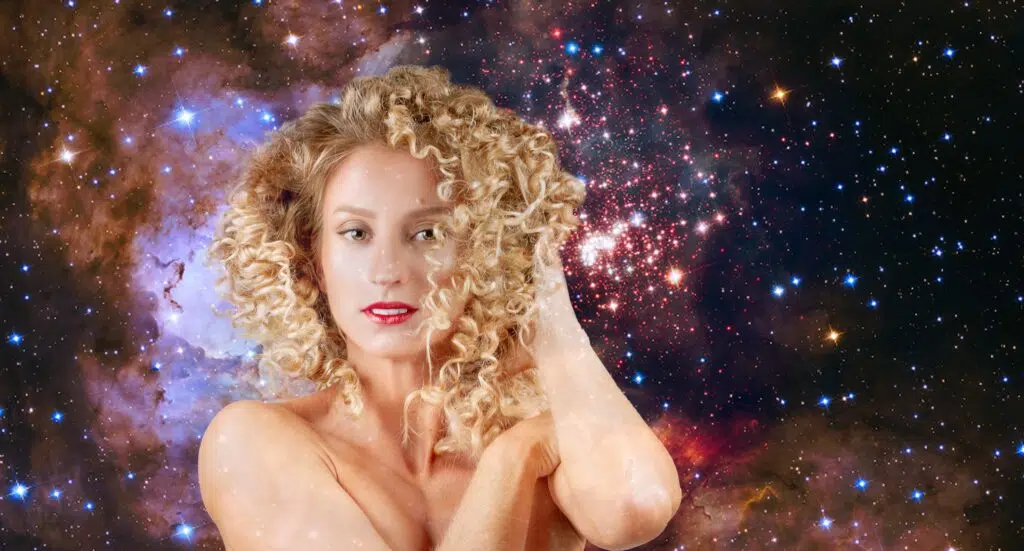 Une jeune femme aux cheveux bouclés  sur un fond de galaxie avec des étoiles.